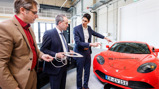Dr. Bernd Eckardt (Abteilungsleiter Leistungselektronik Fraunhofer IISB), StM Hubert Aiwanger (StMWi), Prof. Florian Risch (Abteilungsleiter E|Road-Center Fraunhofer IISB) bei der Begutachtung einer induktiven Ladevorrichtung für Elektrofahrzeuge