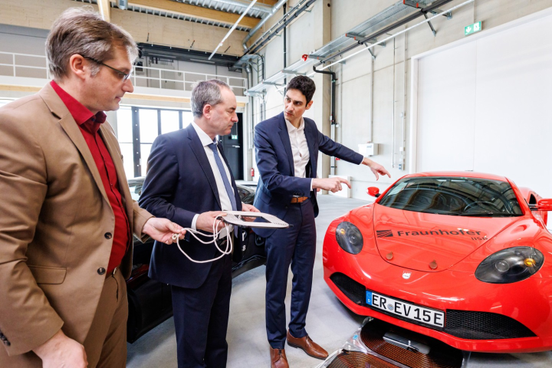 v.l.n.r.: Dr. Bernd Eckardt (Abteilungsleiter Leistungselektronik Fraunhofer IISB), StM Hubert Aiwanger und Prof. Florian Risch (Abteilungsleiter E|Road-Center Fraunhofer IISB) bei der Begutachtung einer induktiven Ladevorrichtung für Elektrofahrzeuge