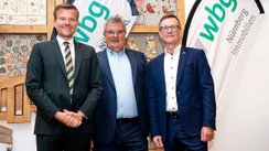 Foto: Julian Wachtler, wbg Nürnberg: Der Vorsitzende der Aufsichtsräte der wbg Unternehmensgruppe Oberbürgermeister Marcus König verabschiedete im Beisein der Mitarbeitenden der wbg Nürnberg GmbH und der WBG KOMMUNAL GmbH Geschäftsführer Frank Thyroff (Mitte) in den Ruhestand und führte Geschäftsführer Ralf Schekira (rechts) als Alleingeschäftsführer ein.